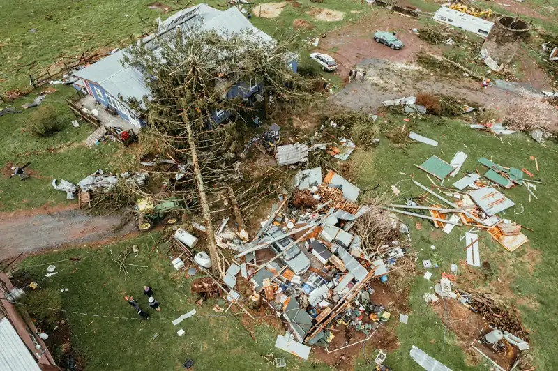 A house and fallen trees after a tornado