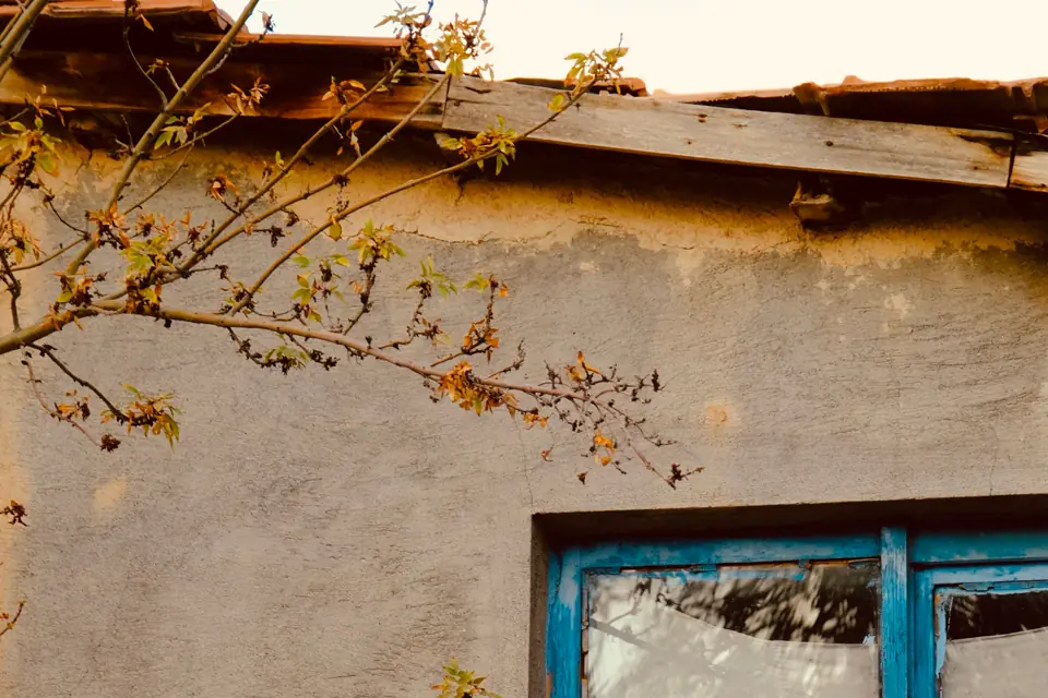 Cracked glass in a blue window on a house wall