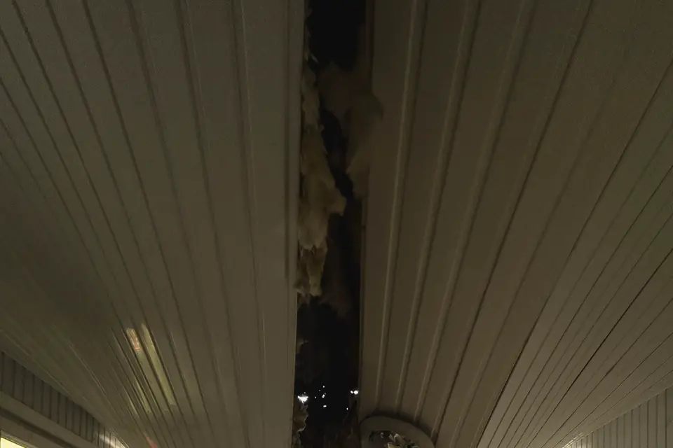 Ceiling with a hole and stained plaster in a room